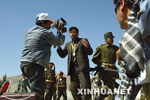 4月27日，在阿富汗首都喀布爾舉行的抗擊蘇聯入侵勝利16周年閱兵慶典上，阿富汗記者在發生武裝襲擊的現場進行報道。當天，阿富汗抗擊蘇聯入侵勝利16周年閱兵慶典遭到塔利班武裝襲擊，多名阿富汗官員受傷，總統卡爾扎伊及時撤離沒有受傷。塔利班武裝發言人穆賈希德隨后聲稱對襲擊事件負責。 新華社發（扎比攝） 