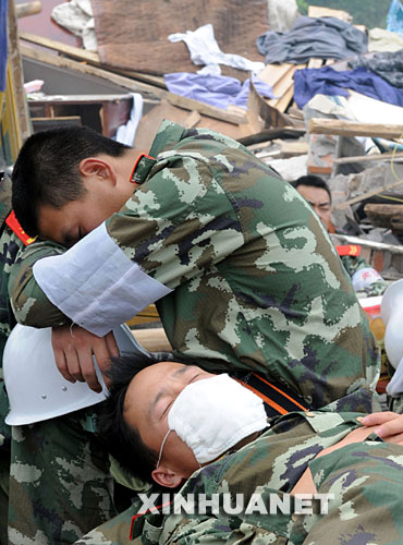 5月17日，救援人員在四川省什邡市救災(zāi)現(xiàn)場抓緊時間小憩。 汶川地震發(fā)生后，救援人員奔赴各個災(zāi)區(qū)，爭分奪秒、夜以繼日地在搜救現(xiàn)場奮戰(zhàn)。為了盡量多地救出掩埋在廢墟下的生還者，他們與時間賽跑，利用有限的空閑稍事休息，補充體力。