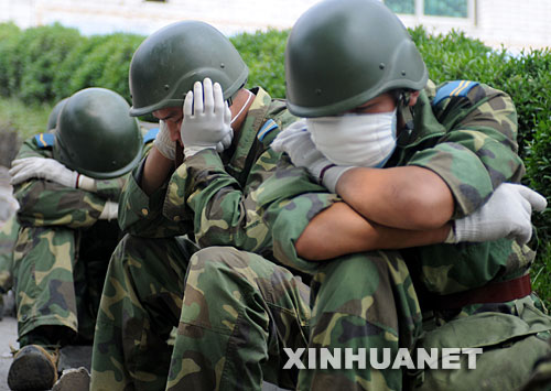 5月17日，救援人員在四川省什邡市救災(zāi)現(xiàn)場抓緊時間小憩。 汶川地震發(fā)生后，救援人員奔赴各個災(zāi)區(qū)，爭分奪秒、夜以繼日地在搜救現(xiàn)場奮戰(zhàn)。為了盡量多地救出掩埋在廢墟下的生還者，他們與時間賽跑，利用有限的空閑稍事休息，補充體力。