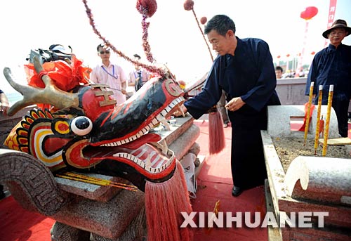 6月2日，祭司正在賽前祭龍頭。 當日，“我們的節日·端午節”主題文化活動暨第三屆中國汨羅江國際龍舟邀請賽在湖南汨羅市舉行。來自澳大利亞、荷蘭以及中國各地的十幾支龍舟隊在汨羅江參加角逐。汨羅是中國古代偉大詩人屈原晚年生活、創作和投江殉國之地。 新華社記者 李尕 攝 