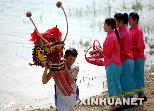 6月2日，一名龍舟隊員正在汨羅江邊祭龍頭。 當日，“我們的節日·端午節”主題文化活動暨第三屆中國汨羅江國際龍舟邀請賽在湖南汨羅市舉行。來自澳大利亞、荷蘭以及中國各地的十幾支龍舟隊在汨羅江參加角逐。汨羅是中國古代偉大詩人屈原晚年生活、創作和投江殉國之地。 新華社記者 李尕 攝 