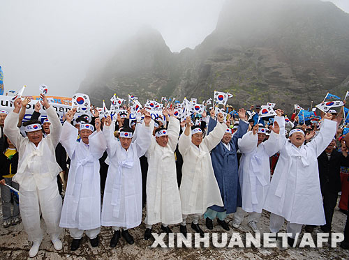  7月14日，大批韓國人在獨島（日本稱“竹島”）手舉國旗抗議。韓國外交通商部發言人文太暎當日發表聲明，強烈抗議日本在當天公布的中學教科書指導手冊中將獨島（日本稱“竹島”）表述為日本領土，并要求日本立即對有關內容進行修正。韓國外交通商部將采取召回韓國駐日本大使和召見日本駐韓國大使這兩項外交措施，就此問題向日本政府表示強烈抗議。 新華社/法新 