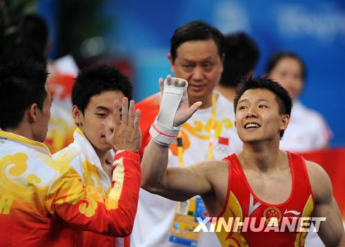  8月9日，中國選手陳一冰（右）在完成他的吊環動作后和隊友楊威擊掌致意。陳一冰的吊環資格賽成績為16.525分。當日，中國隊在北京奧運會體操男子資格賽第二場的比賽中，以374.675分的總成績暫列資格賽第一。