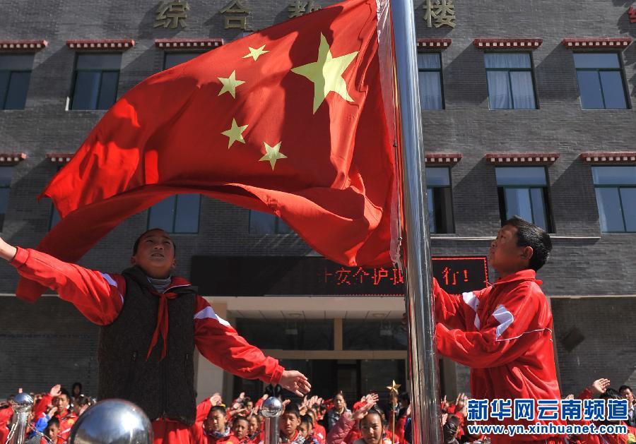 3月17日，云南省迪慶藏族自治州德欽縣第一小學學生在教學樓前參加升旗儀式。新華社 藺以光 攝