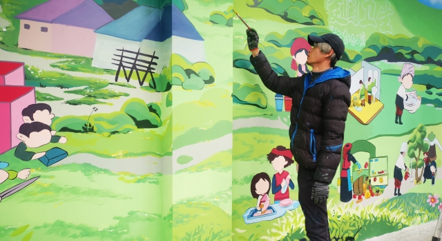 六百工作室的繪制人員描繪愛國衛生運動“7個專項行動”墻畫
