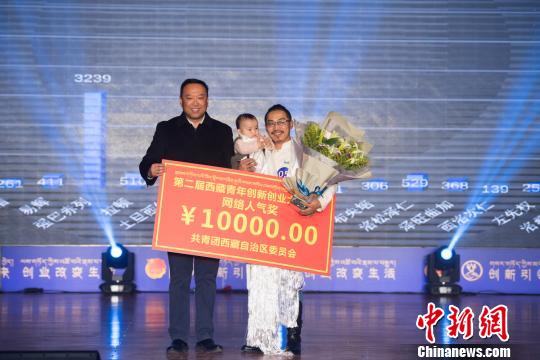圖為強(qiáng)巴(右一)的本土文化創(chuàng)意項(xiàng)目獲得網(wǎng)絡(luò)人氣獎(jiǎng)?！『闻罾?攝