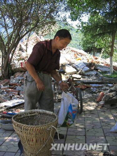 7月5日，北川縣城的一位居民在縣城內尋找自己的物品。當日，記者經特許進入地震重災區北川縣城采訪，用相機記錄下北川縣城的現狀。 